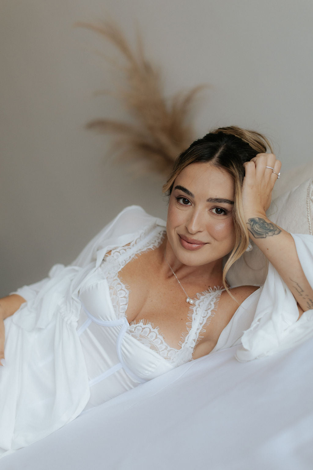 Noiva deitada sorrindo, de corset de renda e robe